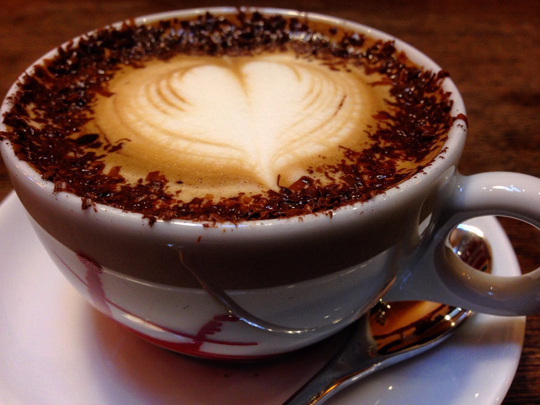 Ceramic cup of source-identified marocchino with pale milk foam and a dark chocolate-coloured rim.